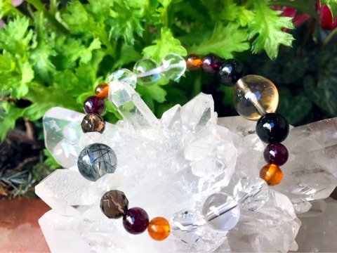 店内の水晶のかたまりに掛けた、色とりどりの天然石のブレスレット